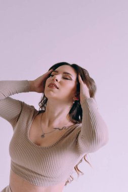 Güzel makyajlı, saç stili olan, kalıcı makyaj uzmanı, elinde aletler tutan lüks bir kız. Fotoğraf stüdyosunda takım elbiseli, kot pantolonlu ve gömlekli bir fotoğrafçı..