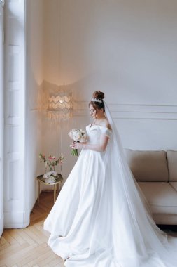 Balkonda ve kanepede bornozlu güzel, seksi bir gelinin sabah hazırlıkları.