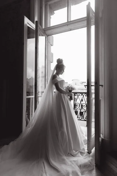 美しいの朝の準備 バルコニーのバスローブでセクシーな花嫁とソファ 彼女は結婚式のドレスに靴を着る場所 — ストック写真