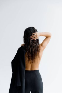 Fotoğraf stüdyosundaki lüks, seksi ve güzel bir kız siyah pantolon giyip şık bir şekilde poz veriyor.