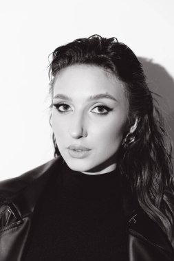 Kısa elbiseli ve deri ceketli güzel bir manken, bir moda şehrinin fotoğraf çekiminde poz veriyor, şehirde dolaşıyor..