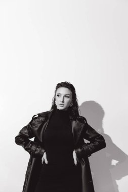 Kısa elbiseli ve deri ceketli güzel bir manken, bir moda şehrinin fotoğraf çekiminde poz veriyor, şehirde dolaşıyor..