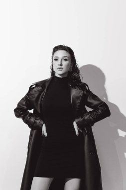 Kısa elbiseli ve deri ceketli güzel bir manken, bir moda şehrinin fotoğraf çekiminde poz veriyor, şehirde dolaşıyor..