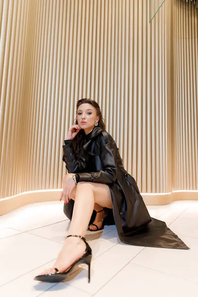 Kısa elbiseli ve deri ceketli güzel bir manken, bir moda şehrinin fotoğraf çekiminde poz veriyor, şehirde dolaşıyor..