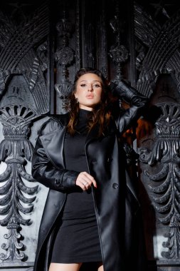 Kısa elbiseli ve deri ceketli güzel bir manken, bir moda şehrinin fotoğraf çekiminde poz veriyor, şehirde dolaşıyor..