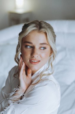 Gelinin sabahı, şık saçlı ve makyajlı bir bornozla güzel lüks bir otelde düğüne hazırlanır ve sonra beyaz bir gelinlik giyer..