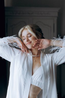 Gelinin sabahı, şık saçlı ve makyajlı bir bornozla güzel lüks bir otelde düğüne hazırlanır ve sonra beyaz bir gelinlik giyer..