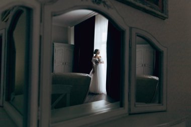 Gelinin sabahı, şık saçlı ve makyajlı bir bornozla güzel lüks bir otelde düğüne hazırlanır ve sonra beyaz bir gelinlik giyer..