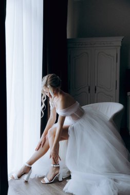 Gelinin sabahı, şık saçlı ve makyajlı bir bornozla güzel lüks bir otelde düğüne hazırlanır ve sonra beyaz bir gelinlik giyer..