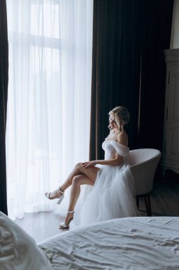 Gelinin sabahı, şık saçlı ve makyajlı bir bornozla güzel lüks bir otelde düğüne hazırlanır ve sonra beyaz bir gelinlik giyer..