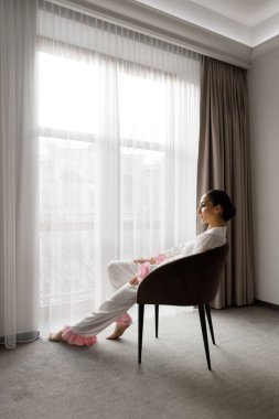 Günaydın ve lüks bir odada, pijama ve iç çamaşırlarıyla lüks ve güzel bir geline ayakkabı ve şık beyaz bir gelinlik giymeye hazırlanıyorum..