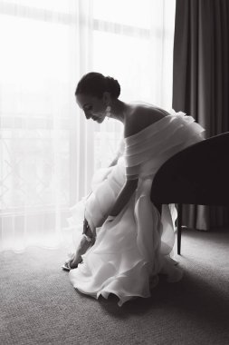 Günaydın ve lüks bir odada, pijama ve iç çamaşırlarıyla lüks ve güzel bir geline ayakkabı ve şık beyaz bir gelinlik giymeye hazırlanıyorum..