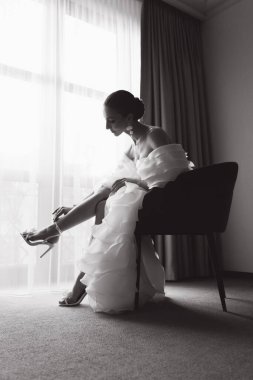 Günaydın ve lüks bir odada, pijama ve iç çamaşırlarıyla lüks ve güzel bir geline ayakkabı ve şık beyaz bir gelinlik giymeye hazırlanıyorum..