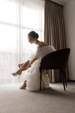 Günaydın ve lüks bir odada, pijama ve iç çamaşırlarıyla lüks ve güzel bir geline ayakkabı ve şık beyaz bir gelinlik giymeye hazırlanıyorum..