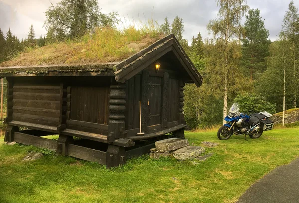 Norveç 'te bir kamp alanında BMW R1250 G ile geleneksel bir dağ kulübesi.