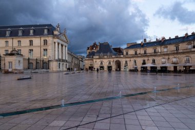 Dijon, Fransa 15 Nisan 2023: Şatolu Dijon ve yağmurlu bir akşamda dükkanlar ve restoranlar da dahil olmak üzere ön bahçe
