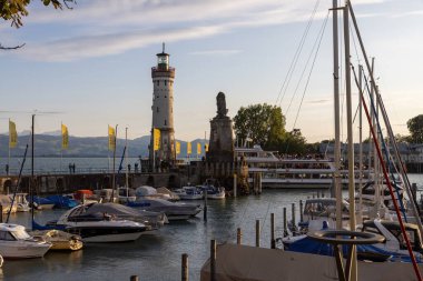 Lindau, Almanya 5 Ağustos 2023: Lindau, bir gezinti teknesi ve bir deniz feneri ve aslan girişli liman girişi