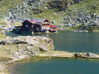Romanya 'da ev ve dağlarla Balea Gölü manzarası