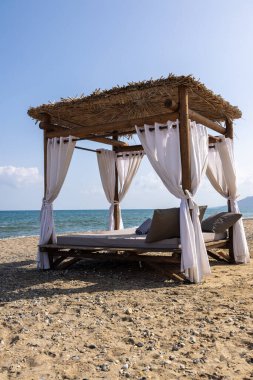 Sahilde sahil yatağı olan Girit, tipik güneşli çatı ve deniz