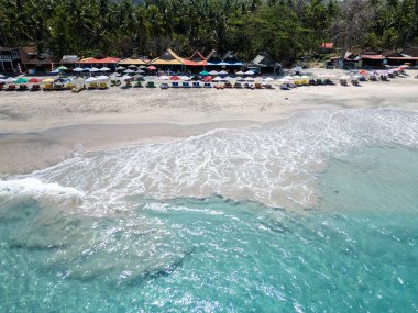 Bali 'de otel kompleksi, deniz, sahil ve tekneleri olan körfez, insansız hava aracı fotoğrafı.