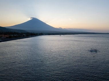 Akşamları Bali 'de volkan, deniz, sahil ve şehirli körfez, insansız hava aracı fotoğrafı.