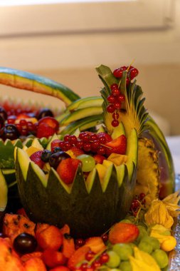 Çeşitli meyvelerle süslenmiş meyve sepeti.