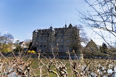 old, historic Neuenstein moated castle in the Neuenstein district of Oehringen in spring clipart