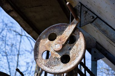 Tahta kirişe bağlı eski, paslı el kolu.