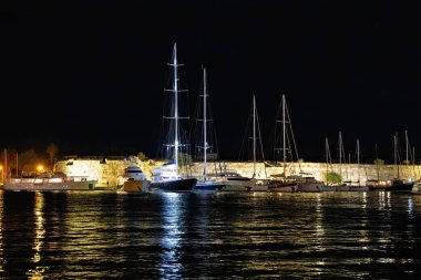 Yunanistan 'daki Kos limanında bir yaz gecesinde ışık ve yansımalarla çekilen gemiler