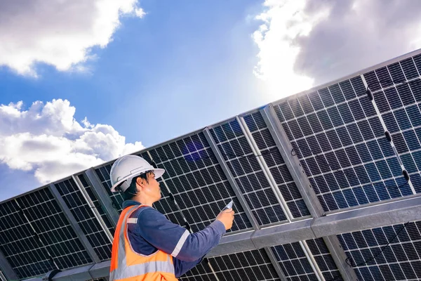 stock image Technicians are checking the operation of the solar power plant equipment so that the power generation can operate at full capacity. Alternative energy to conserve the world's energy.