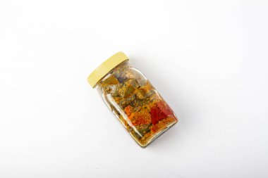 Beyaz arka planda sarı başlıklı mango turşusu kavanozu