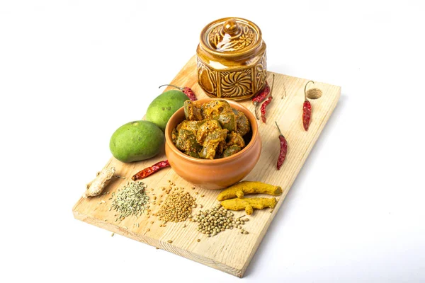 Mango Pickle setup with jar on wooden background with green mango slices
