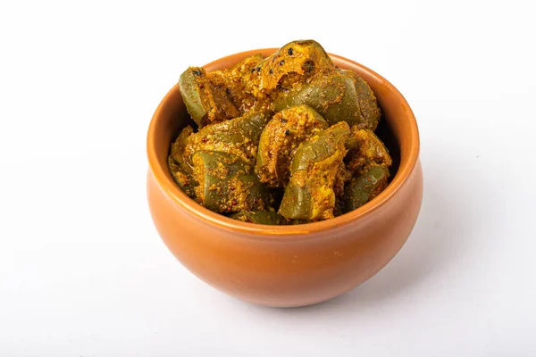 Mango Pickle in brown bowl in white backgroun