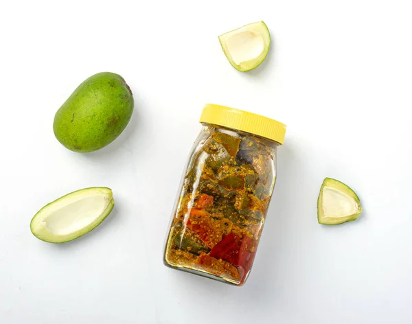 Mango Pickle jar with pieces of raw green mangoes on white backgroun