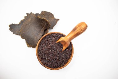 Beyaz arka planda hardal tohumları ve hardal keki.