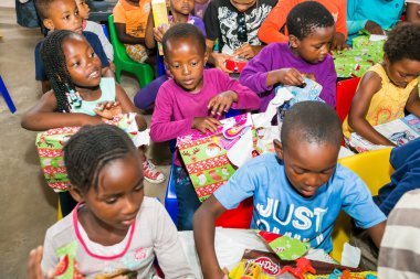 Johannesburg, Güney Afrika - 15 Aralık 2016: Genç Afrikalı okul çocukları Noel hediyelerini açıyor