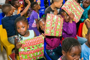 Johannesburg, Güney Afrika - 15 Aralık 2016: Genç Afrikalı okul çocukları Noel hediyelerini açıyor