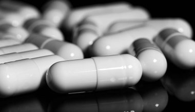 Makro, siyah arka planda beyaz ağrı kesici kapsülünü kapat.