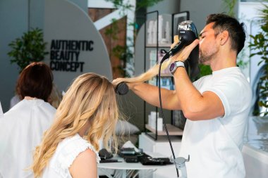 Cape Town, Güney Afrika - 15 Kasım 2022: Kuaförde genç bayan modeller üzerinde çalışan profesyonel stilist