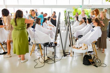 Cape Town, Güney Afrika - 15 Kasım 2022: Kuaförde genç bayan modeller üzerinde çalışan profesyonel stilist