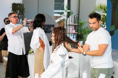 Cape Town, Güney Afrika - 15 Kasım 2022: Kuaförde genç kadın modelle gösteri yapan profesyonel stilist