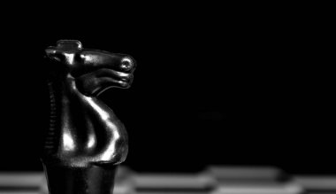 Yansıtıcı ayna yüzeyindeki siyah arkaplanı olan satranç taşlarını kapat