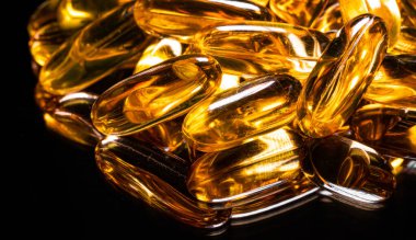 Omega 3 jel kapsülünü yansıtıcı siyah arka planda kapat