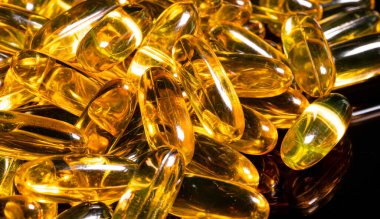 Omega 3 jel kapsülünü yansıtıcı siyah arka planda kapat