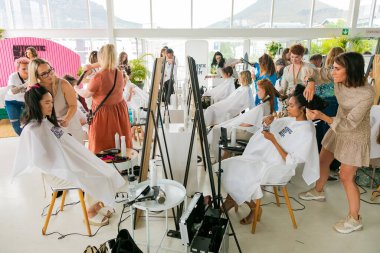 Cape Town, Güney Afrika - 15 Kasım 2022: Kuaförde genç bayan modeller üzerinde çalışan profesyonel stilist