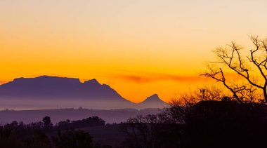 Silhouette of Table Mountain against a dusk sunset sky in Cape Town, South Africa