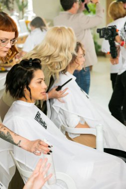 Cape Town, Güney Afrika - 15 Kasım 2022: Kuaförde genç bayan modeller üzerinde çalışan profesyonel stilist