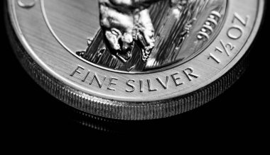 Macro Siyah ayna arkaplanındaki gümüş külçe sikkeyi kapat