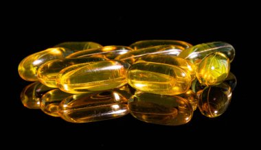 Omega 3 jel kapsülünü yansıtıcı siyah arka planda kapat