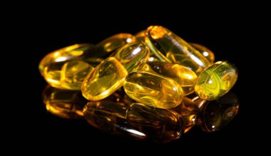 Omega 3 jel kapsülünü yansıtıcı siyah arka planda kapat